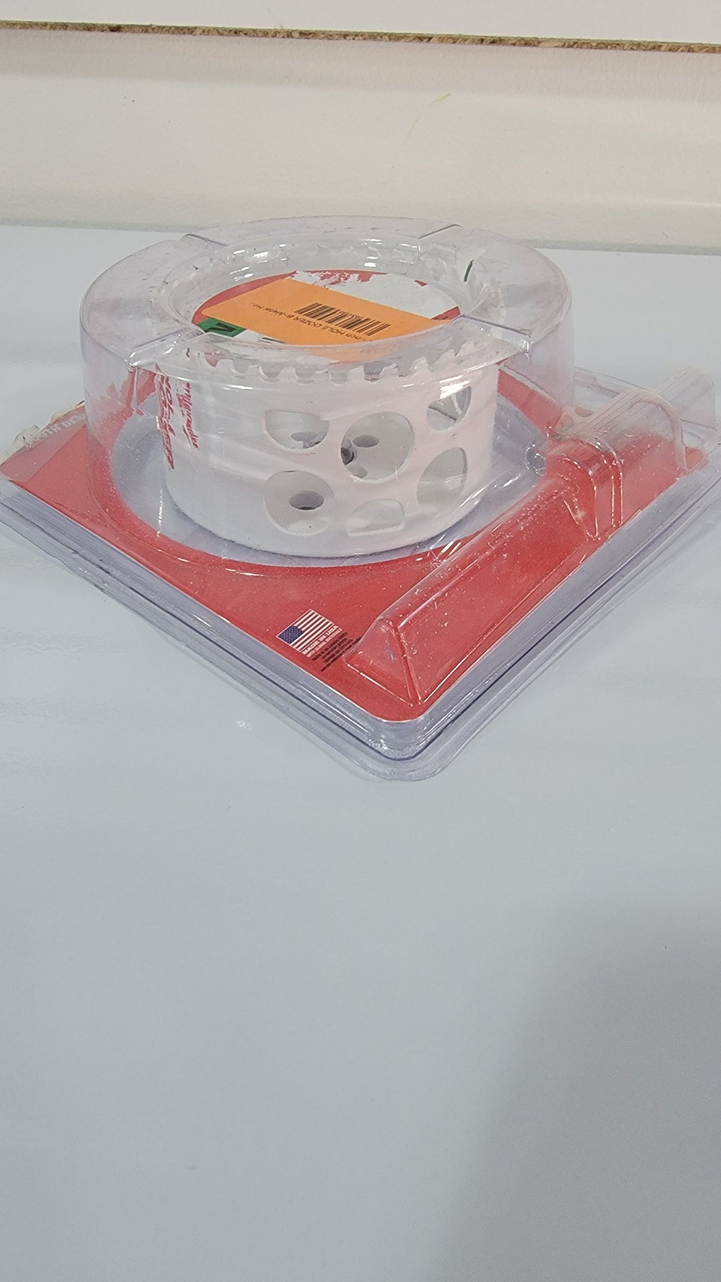 A clear plastic packaging showcases the Milw 3-1/2-inch HOLE DOZER Bi-Metal Hole Saw with a pilot bit and 3/8-inch arbor, all elegantly displayed on a vibrant red base.