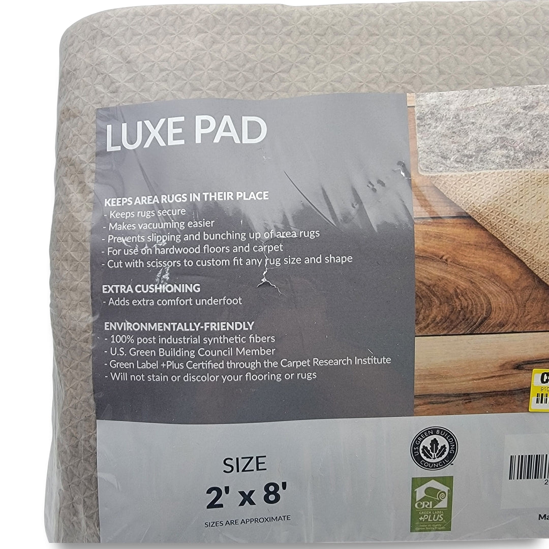 Packaging for a Luxe pad keep area rugs in place rug gripper highlights features like extra cushioning and environmental friendliness. Size: 2' x 8'.