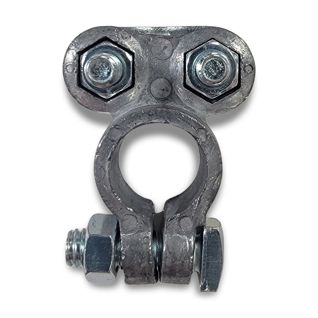 A battery terminal with a metallic clamp featuring two hexagonal bolts on top and one on the side, giving it an anthropomorphic appearance.