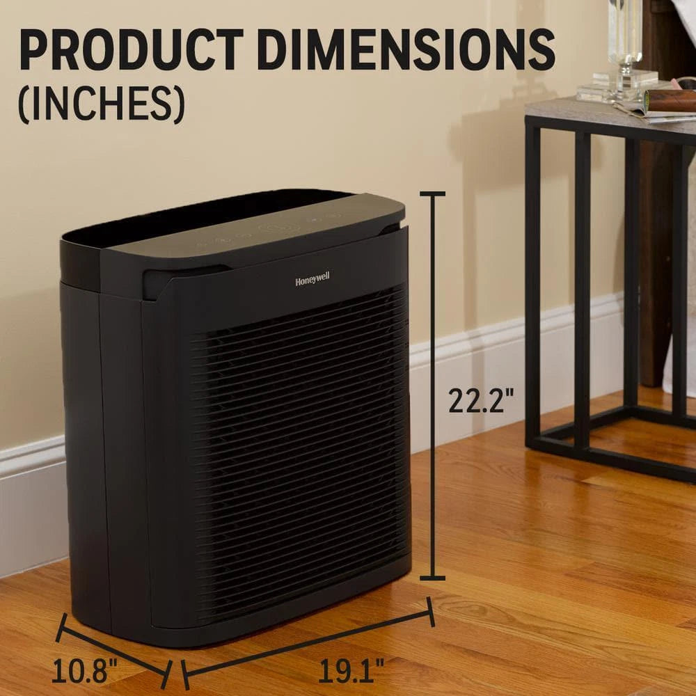 The Honeywell Power Plus HEPA Air Purifier, suitable for rooms up to 530 sq ft, is a black rectangular unit measuring 22.2" tall, 19.1" wide, and 10.8" deep, placed on a wooden floor next to a table.