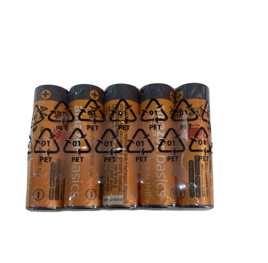 Five AA batteries, wrapped in clear plastic packaging, rest on a speckled white surface.