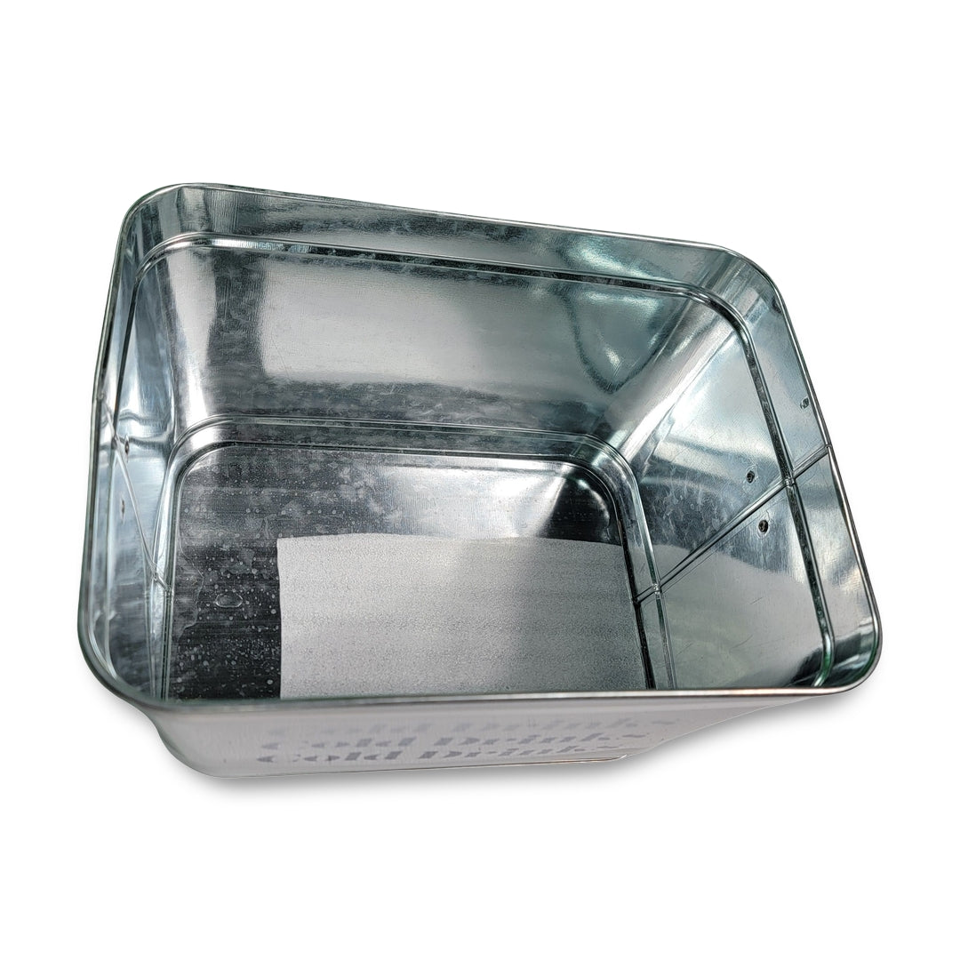 The Cold Drinks Bucket is a rectangular metal container with a reflective surface, featuring an unattached piece of paper lying flat at its bottom.
