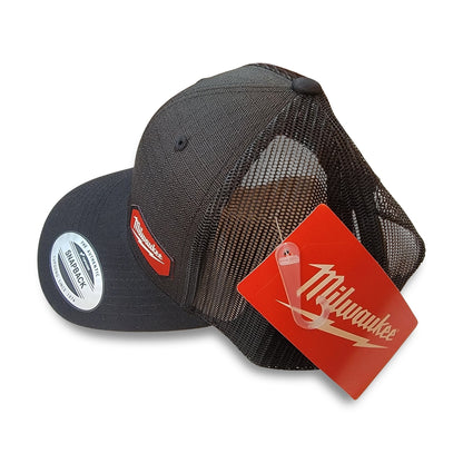 Milwaukee Black Snapback Hat featuring a red Milwaukee logo patch on the front and a red Milwaukee tag attached, positioned with the front facing left.