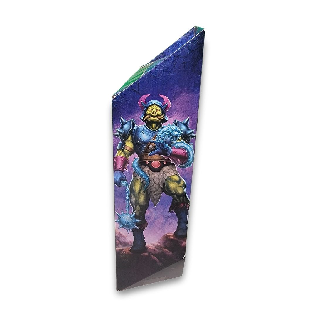 Triangular prism-shaped box displaying the Masters of the Universe Masterverse Pig-Head Action figure, illustrated as a fantasy warrior with a blue spiked mace and purple armor, set against a purple sky background.