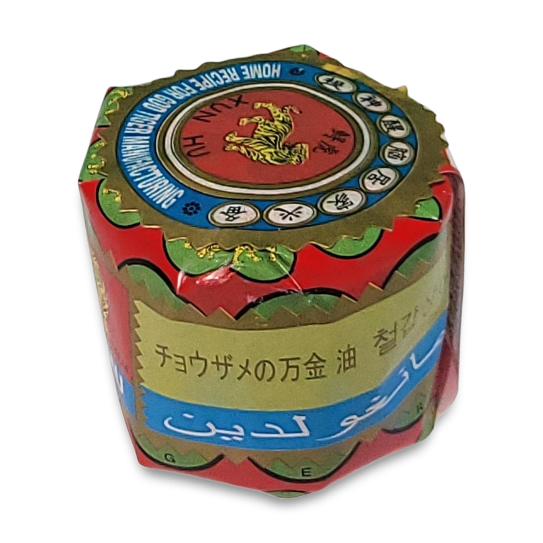 Hexagonal package labeled with vibrant designs featuring a tiger, and multilingual text in Japanese and Arabic for Tiger Ointment.